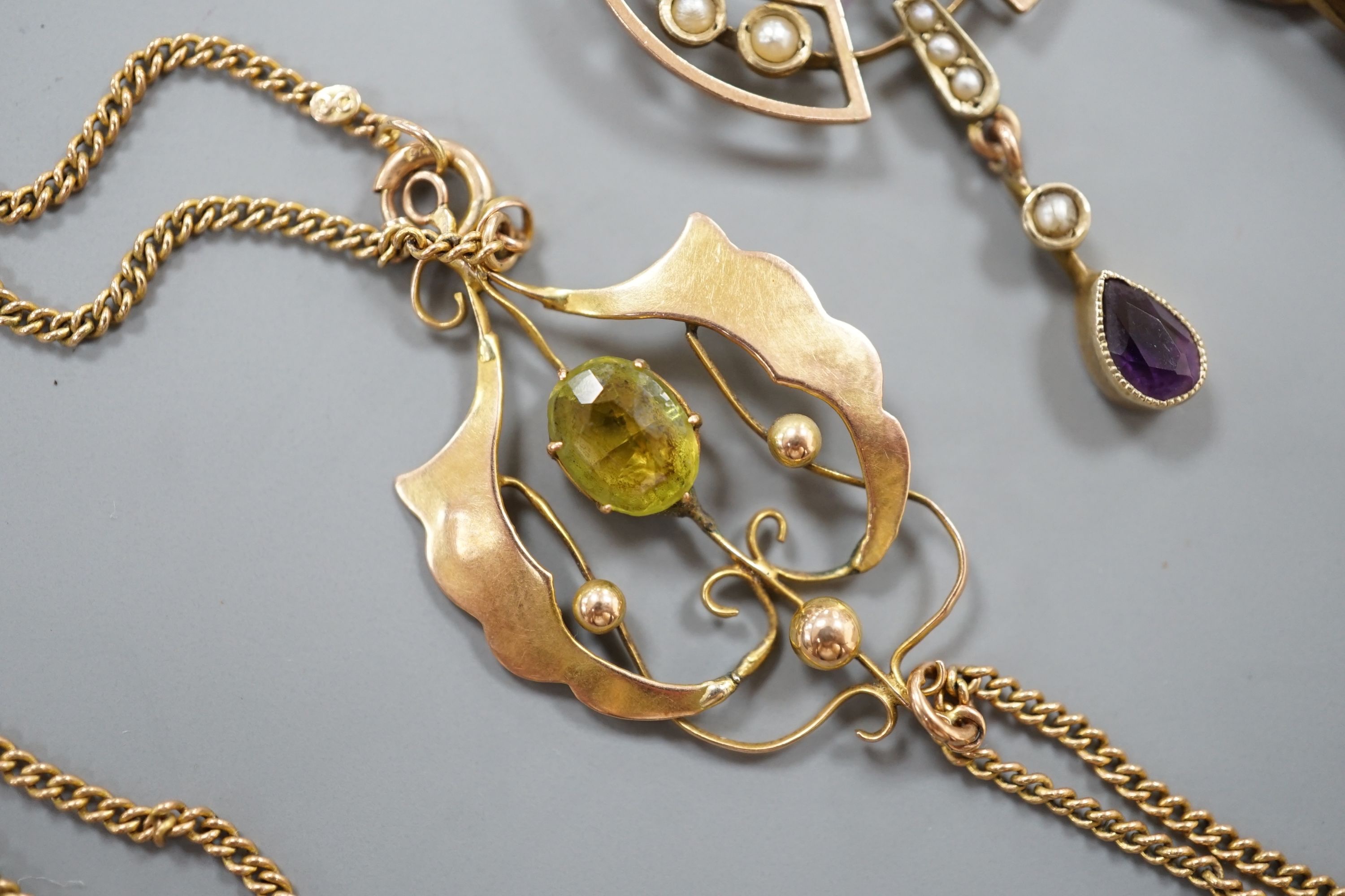Three early 20th century yellow metal and gem set drop pendants, including two stamped 9ct and two with 9ct chains, largest 5cm, gross weight 10.1 grams, two other pendants and a yellow metal and split pearl set oval bro